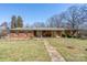 Classic brick home featuring a welcoming front porch and a stone walkway at 624 Patricia Ave, Harrisburg, NC 28075