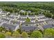 Aerial view of townhomes highlighting manicured lawns, garages, back patios, and mature trees at 6846 Colonial Garden Dr, Huntersville, NC 28078