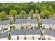Aerial view of townhomes featuring back patios, white fencing, garages, and lush, mature trees at 6846 Colonial Garden Dr, Huntersville, NC 28078
