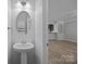 Powder room featuring a pedestal sink and access to a spacious room beyond at 6846 Colonial Garden Dr, Huntersville, NC 28078