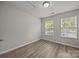 Well-lit bedroom with wood-look flooring and two bright windows at 6846 Colonial Garden Dr, Huntersville, NC 28078