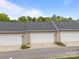 View of multi car garages with neutral color scheme, white doors, and well maintained landscaping at 6846 Colonial Garden Dr, Huntersville, NC 28078