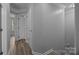 Hallway with neutral paint, white trim, and consistent flooring, leading to various rooms at 6846 Colonial Garden Dr, Huntersville, NC 28078