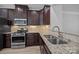 Kitchen area features stainless appliances, granite counters, tile backsplash and dark cabinets at 6846 Colonial Garden Dr, Huntersville, NC 28078
