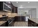 Open kitchen features granite counters, stainless appliances, and dark wood cabinetry at 6846 Colonial Garden Dr, Huntersville, NC 28078