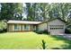 Charming single-story home with a brick facade, lush lawn, and attached garage at 7228 Rollingridge Dr, Charlotte, NC 28211