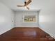 Bright living room featuring a ceiling fan, wood floors, and a large window at 724 Merridale Dr, Charlotte, NC 28214