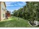 Expansive backyard featuring lush green lawn, a fire pit, and mature trees, providing a serene outdoor space at 7343 Mill Ruins Sw Ave, Concord, NC 28025