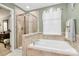 En suite bathroom with a tiled shower, a soaking tub, and a window at 7343 Mill Ruins Sw Ave, Concord, NC 28025