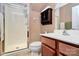 This bathroom features a shower with glass doors, a storage cabinet, and a sink with wood cabinets at 7343 Mill Ruins Sw Ave, Concord, NC 28025