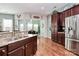 Kitchen view featuring dark wood cabinets, granite countertops, stainless steel appliances, and a view into the dining room at 7343 Mill Ruins Sw Ave, Concord, NC 28025