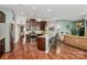 Open concept kitchen featuring stainless steel appliances, dark wood cabinets, granite countertops, and bar seating at 7343 Mill Ruins Sw Ave, Concord, NC 28025