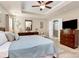 Main bedroom with a tray ceiling, ceiling fan, neutral paint, and blue accents at 7343 Mill Ruins Sw Ave, Concord, NC 28025