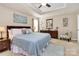 Main bedroom with a tray ceiling, ceiling fan, neutral paint, and blue accents at 7343 Mill Ruins Sw Ave, Concord, NC 28025