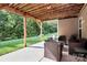 Covered patio with comfortable seating, ideal for enjoying the outdoors in a private and relaxing setting at 7343 Mill Ruins Sw Ave, Concord, NC 28025