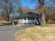 A single-story home with gray siding, a white porch, and a tree-filled yard at 934 W Nc 150 Hwy, Lincolnton, NC 28092