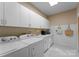 Functional laundry room with ample white cabinets, sink, washer, and dryer at 1025 Seminole Dr, Waxhaw, NC 28173