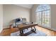 Home office with beautiful hardwood floors, a large arched window, and a classic desk setup at 1025 Seminole Dr, Waxhaw, NC 28173