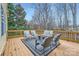 Back deck featuring outdoor furniture with cushions, trees, and a view at 1005 Forbishire Dr, Matthews, NC 28104