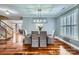 Elegant dining room featuring hardwood floors, modern light fixture, and plantation shutters at 1005 Forbishire Dr, Matthews, NC 28104