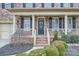 Inviting front entrance with covered porch, decorative columns and manicured shrubbery at 1005 Forbishire Dr, Matthews, NC 28104