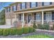 Charming front porch with classic columns, fresh landscaping, and traditional black shutters at 1005 Forbishire Dr, Matthews, NC 28104