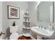 Stylish half bathroom featuring modern fixtures, decorative shelving, and elegant mirror enhancing the space's aesthetic appeal at 1005 Forbishire Dr, Matthews, NC 28104