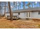 Exterior view of the backyard features a small deck and patio area surrounded by mature trees and foliage at 101 Fairfax Dr, Salisbury, NC 28146