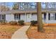 Welcoming home featuring a cozy porch with white railing, mature landscaping, and a winding sidewalk leading to the entrance at 101 Fairfax Dr, Salisbury, NC 28146
