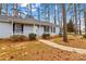 Quaint home with light blue siding, black shutters, and covered front porch surrounded by mature trees and natural landscaping at 101 Fairfax Dr, Salisbury, NC 28146