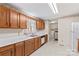 Functional kitchen with wood cabinets, white countertops, and a view into a laundry area with washer and dryer hookups at 101 Fairfax Dr, Salisbury, NC 28146