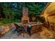 Inviting outdoor stone fireplace with a cozy seating area, perfect for relaxing evenings at 1025 Seminole Dr, Waxhaw, NC 28173