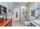 Well-lit bathroom featuring a glass shower, toilet, vanity, and decorative accents with elegant wainscoting at 108 Outside Loop Ln, Mooresville, NC 28117