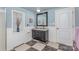 Bathroom featuring a black vanity, large mirror, checkered floor and wainscoting at 108 Outside Loop Ln, Mooresville, NC 28117