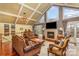 Bright living room featuring vaulted ceiling, fireplace, large windows, hardwood floors, and comfortable seating at 108 Outside Loop Ln, Mooresville, NC 28117