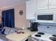 Kitchen area with white cabinets and appliances, adjoining to a cozy sitting area with nautical decor at 110 Shawnee Trl, Mount Gilead, NC 27306