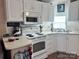 Bright kitchen featuring white cabinets, appliances, and countertops, offering a clean and functional space at 110 Shawnee Trl, Mount Gilead, NC 27306