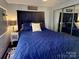 Comfortable bedroom with a plush blue quilt, mirrored closet, and lake-themed decor at 110 Shawnee Trl, Mount Gilead, NC 27306