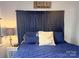 Comfortable main bedroom with a plush blue quilt, decorative pillows, and lake-themed decor at 110 Shawnee Trl, Mount Gilead, NC 27306