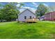 Exterior of home with wooden deck and expansive backyard; lush lawn and trees at 117 Lippard St, Statesville, NC 28677