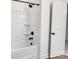 Clean white bathroom featuring a tub and shower with black fixtures and a white door at 117 Lippard St, Statesville, NC 28677