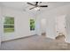 Spacious bedroom with soft carpet, two windows and ceiling fan, adjacent to bathroom and closet at 117 Lippard St, Statesville, NC 28677