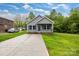 Charming home featuring a long driveway, inviting front porch, and beautiful landscaping at 117 Lippard St, Statesville, NC 28677