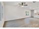 Bright living room features sleek flooring, modern ceiling fan and adjacent kitchen area with white cabinets at 117 Lippard St, Statesville, NC 28677