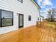 View of the home's back deck, white siding, and black-trimmed windows at 1300 Austin Chaney Rd, Wingate, NC 28174