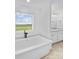 Sunny bathroom with a soaking tub in front of a large window at 1300 Austin Chaney Rd, Wingate, NC 28174