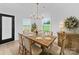 Bright dining room with a rustic table, striped chairs, chandelier, and view of the back yard at 1300 Austin Chaney Rd, Wingate, NC 28174