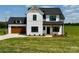 Charming two-story modern farmhouse with a well-manicured lawn and a welcoming, covered front porch at 1300 Austin Chaney Rd, Wingate, NC 28174