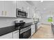 Kitchen features stainless steel appliances, black countertops, white cabinets, and a tiled backsplash at 1300 Austin Chaney Rd, Wingate, NC 28174