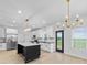 Bright kitchen boasts white cabinets, black countertops, stainless steel appliances, and a center island with stone countertop at 1300 Austin Chaney Rd, Wingate, NC 28174